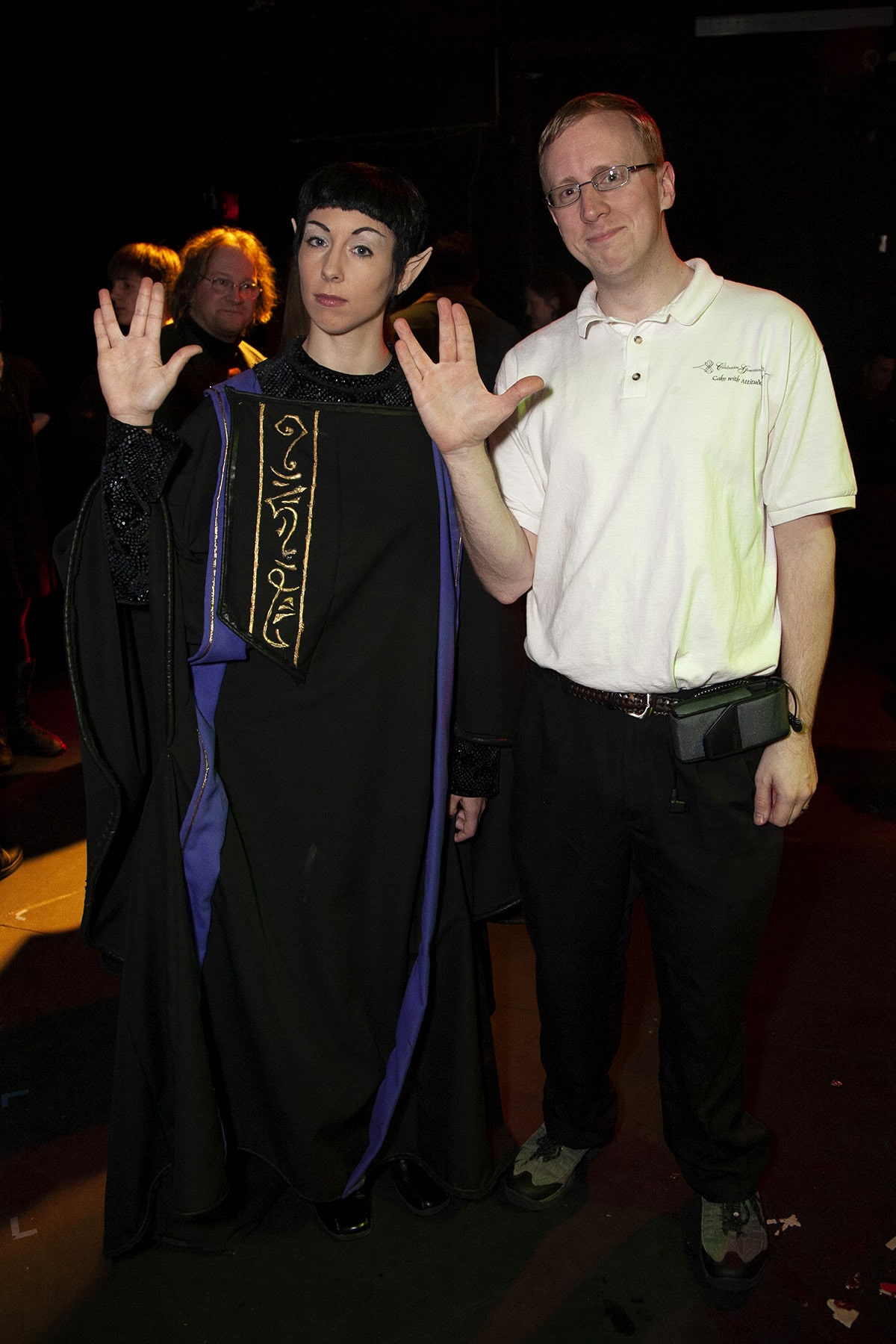 The author's husband poses with a Vulcan actress, both are giving the Vulcan hand salute.