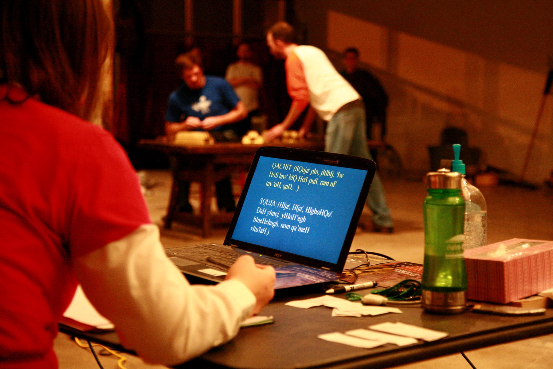 A candid theater practice photo. There is a laptop screen in view, with Klingon language across it.