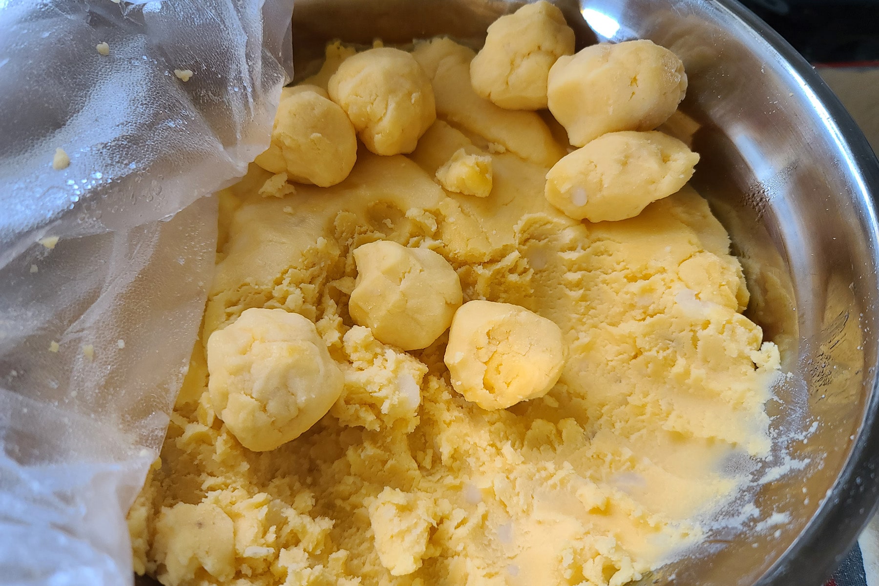 A bowl of cheesy potato filling, with several balls of it on the surface.