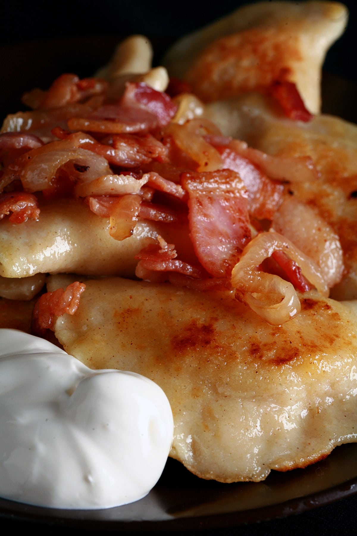 A plate of homemade fried perogies with bacon.