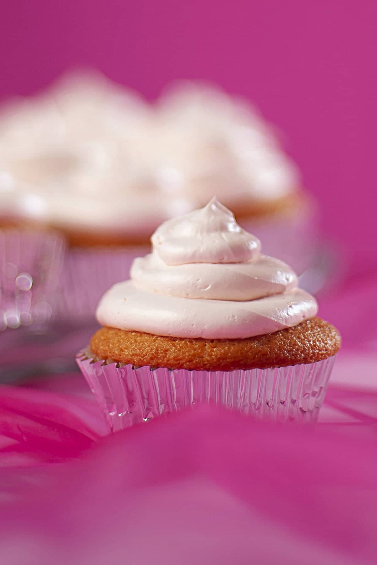A tray of pink grapefruit daiquiri cupcakes - in silver liners, topped with pink frosting.