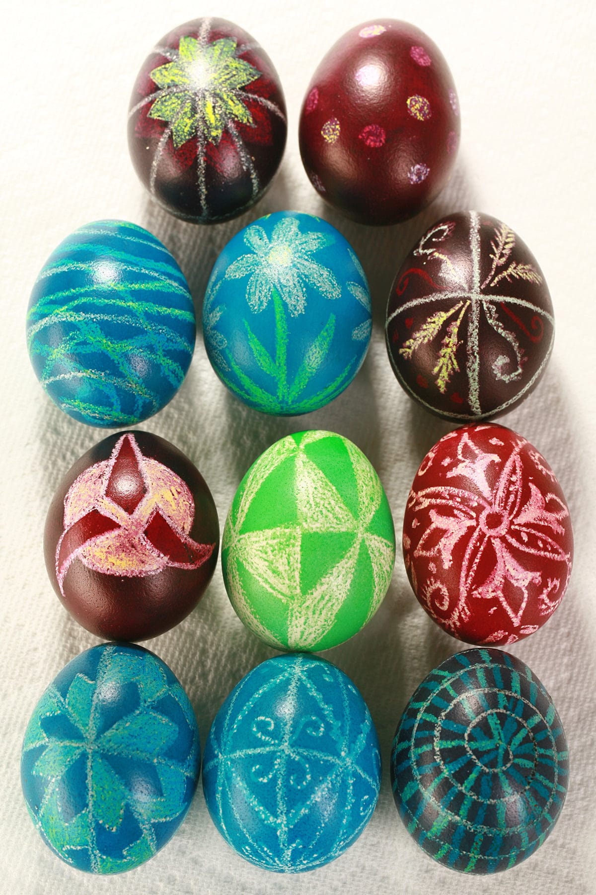Several brightly coloured batik dyed easy Ukrainian easter eggs, on a white background.