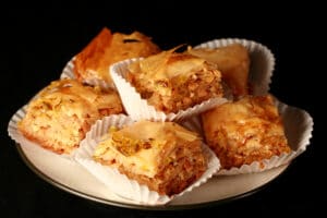 A small stack of squares of jalapeno beer peanut baklava, on a small plate.