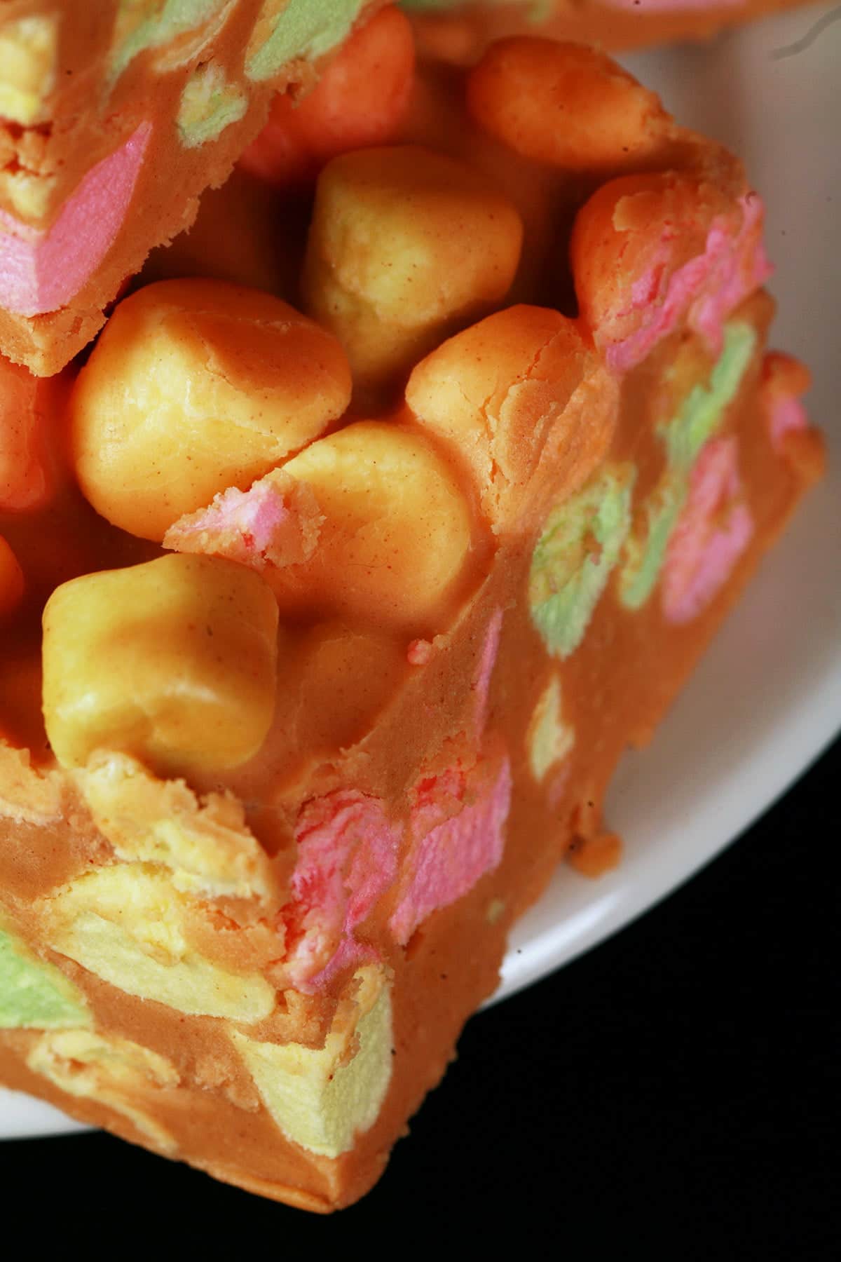 Close up view of butterscotch fudge squares, loaded with rainbow marshmallows.