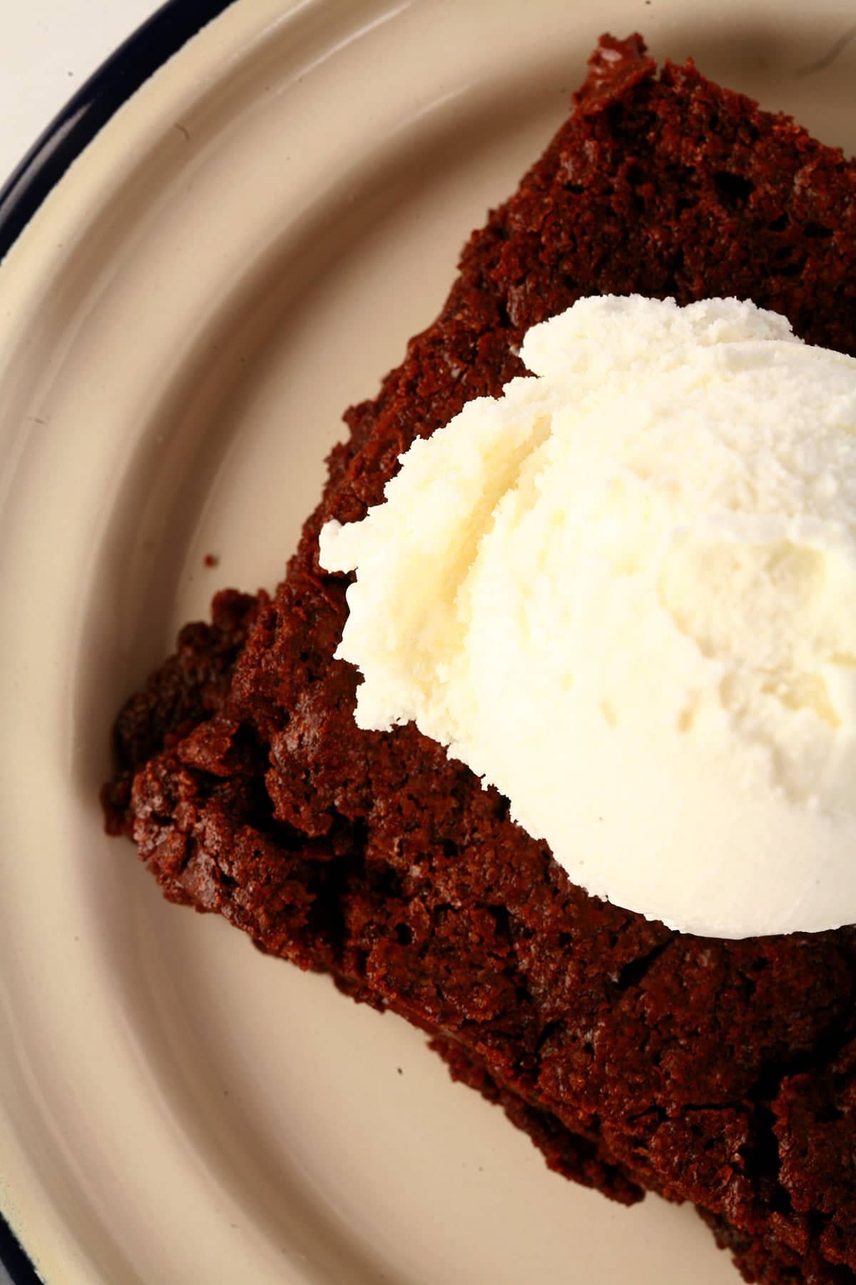 A large double chocolate brownie, topped with vanilla ice cream.