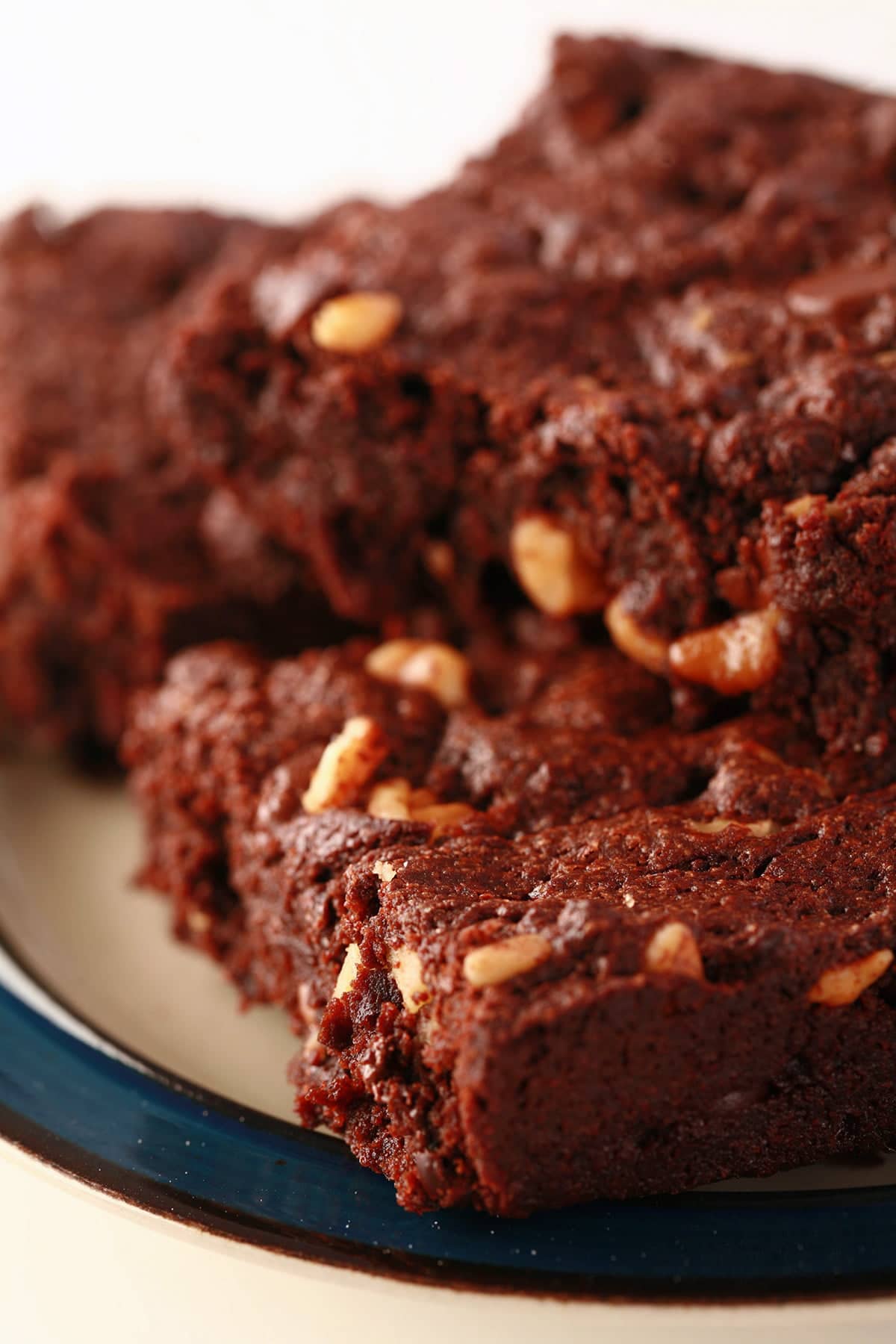 A small plate, piled with 4 double chocolate walnut brownies.