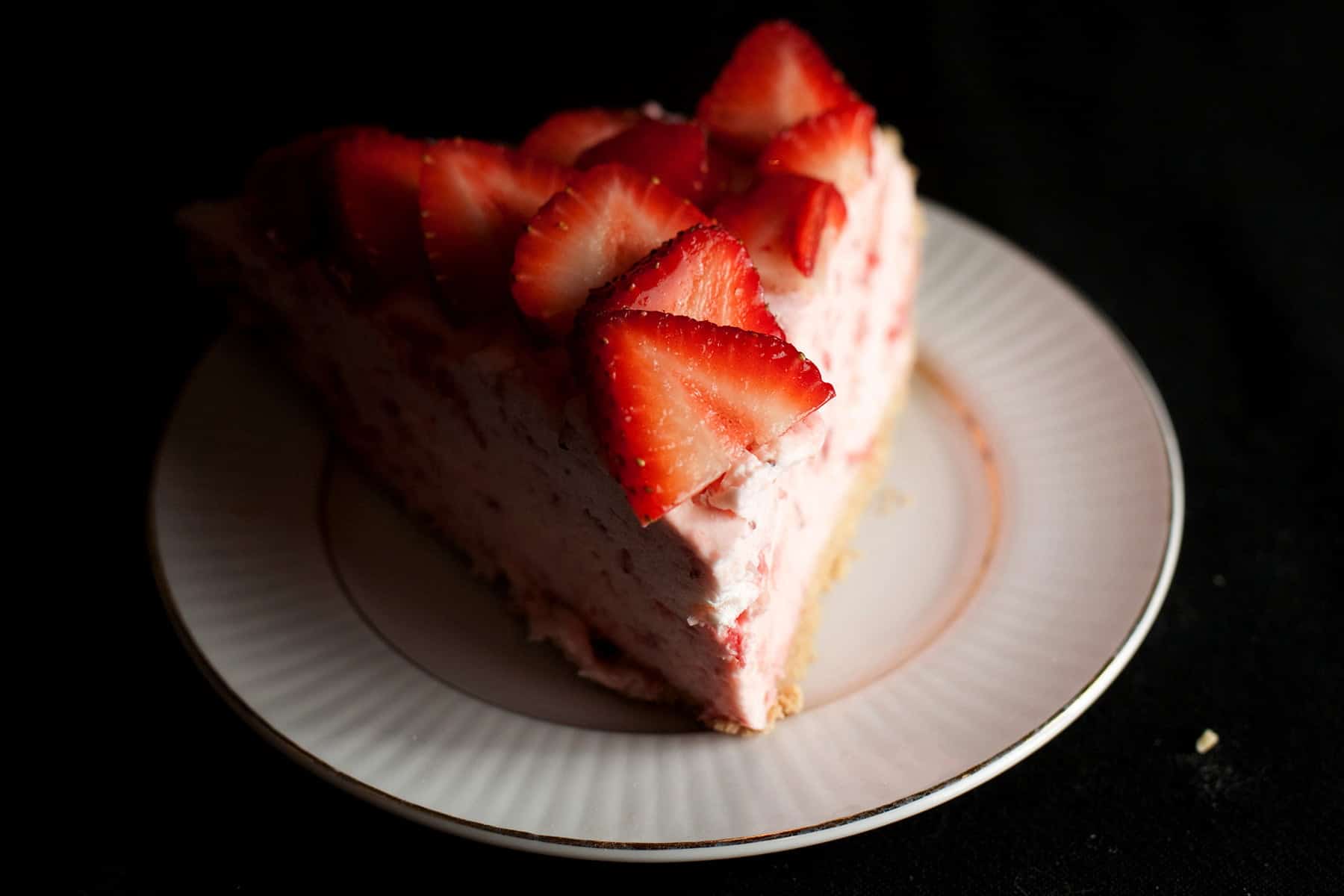 A slice of strawberry Grand Marnier Chiffon Pie on a small white plate.
