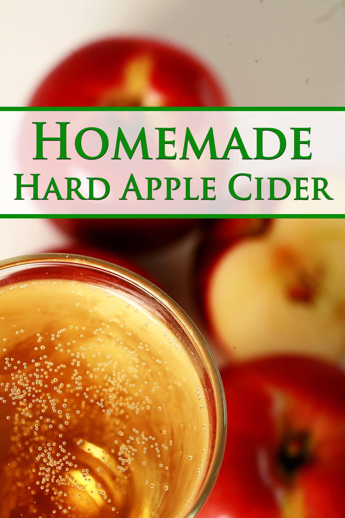 Pinterest image for this Hard Apple Cider recipe.  A close up view of a glass of hard apple cider, with red apples surrounding it.