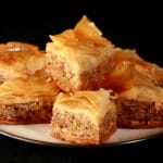 Diamond shaped pieces of maple-walnut baklava, on a small white plate.