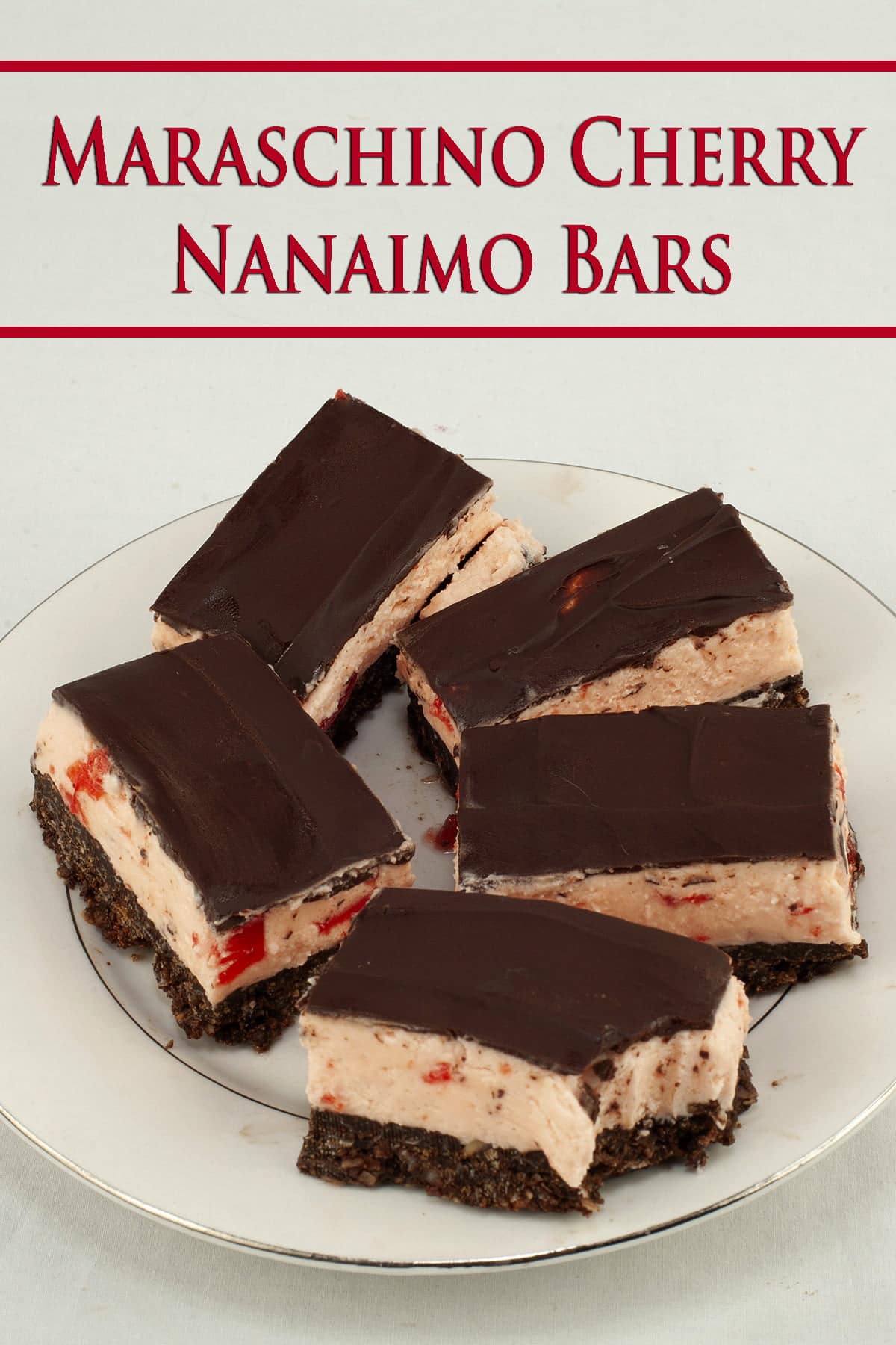 Close up view of a plate of 3 layered bars. The bottom layer looks like a brownie, the middle is a thick pink buttercream with bits of cherry visible, and the top is a smooth chocolate ganache. Maraschino Cherry Nanaimo Bars!