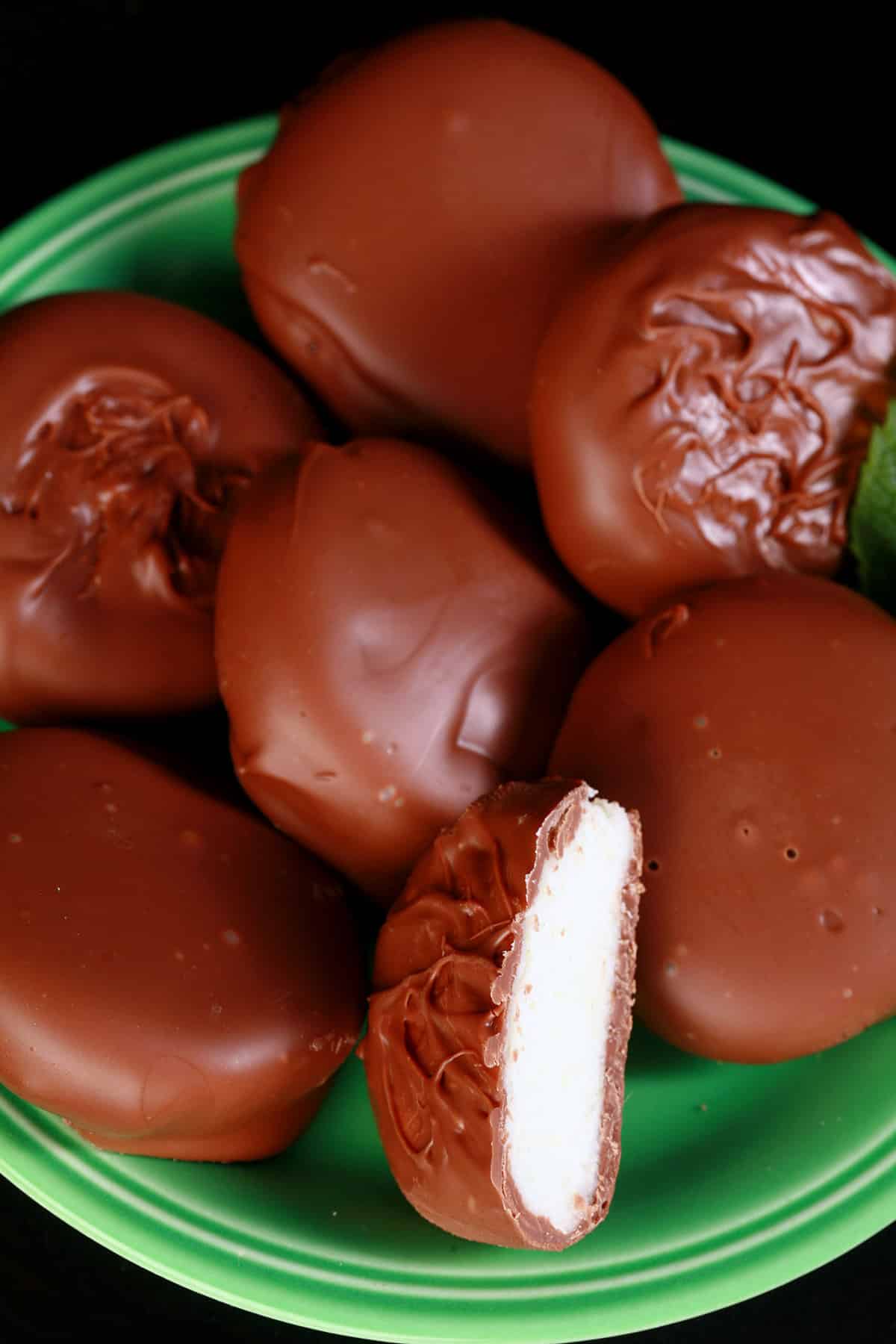Several homemade peppermint patties on a small green plate.