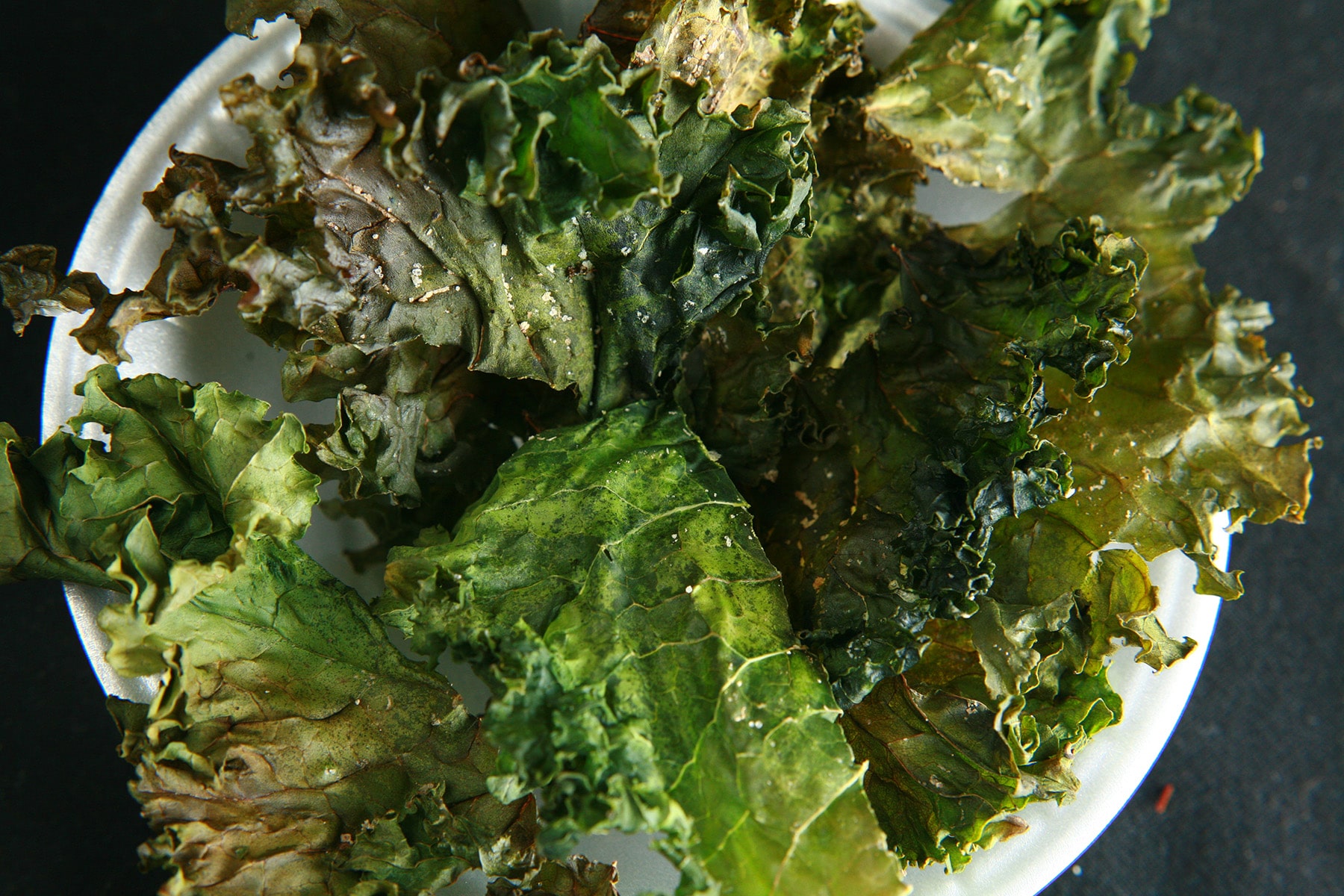 A bowl of deep green kale chips.