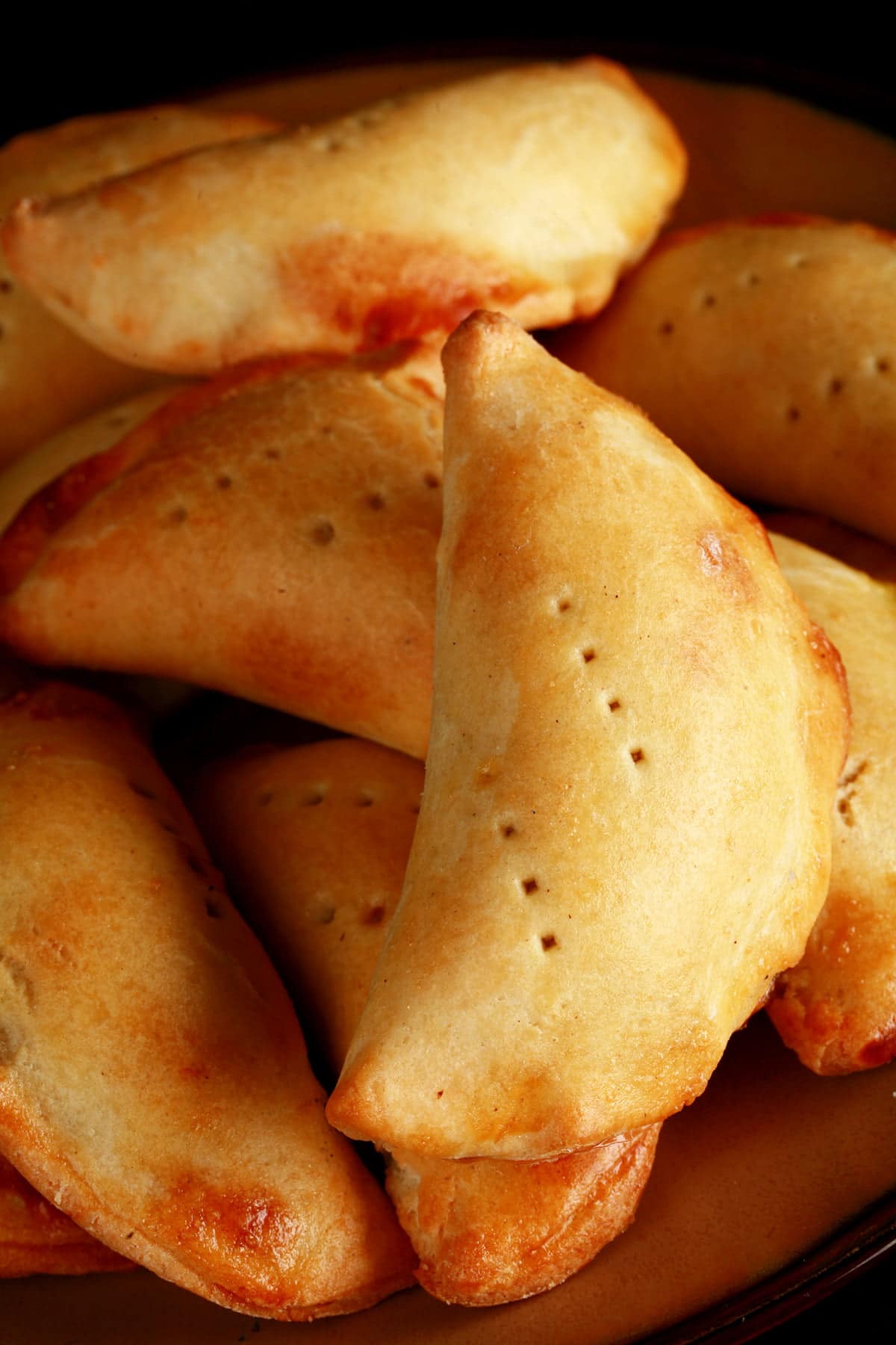 A plate piled with golden brown mushroom turnovers.