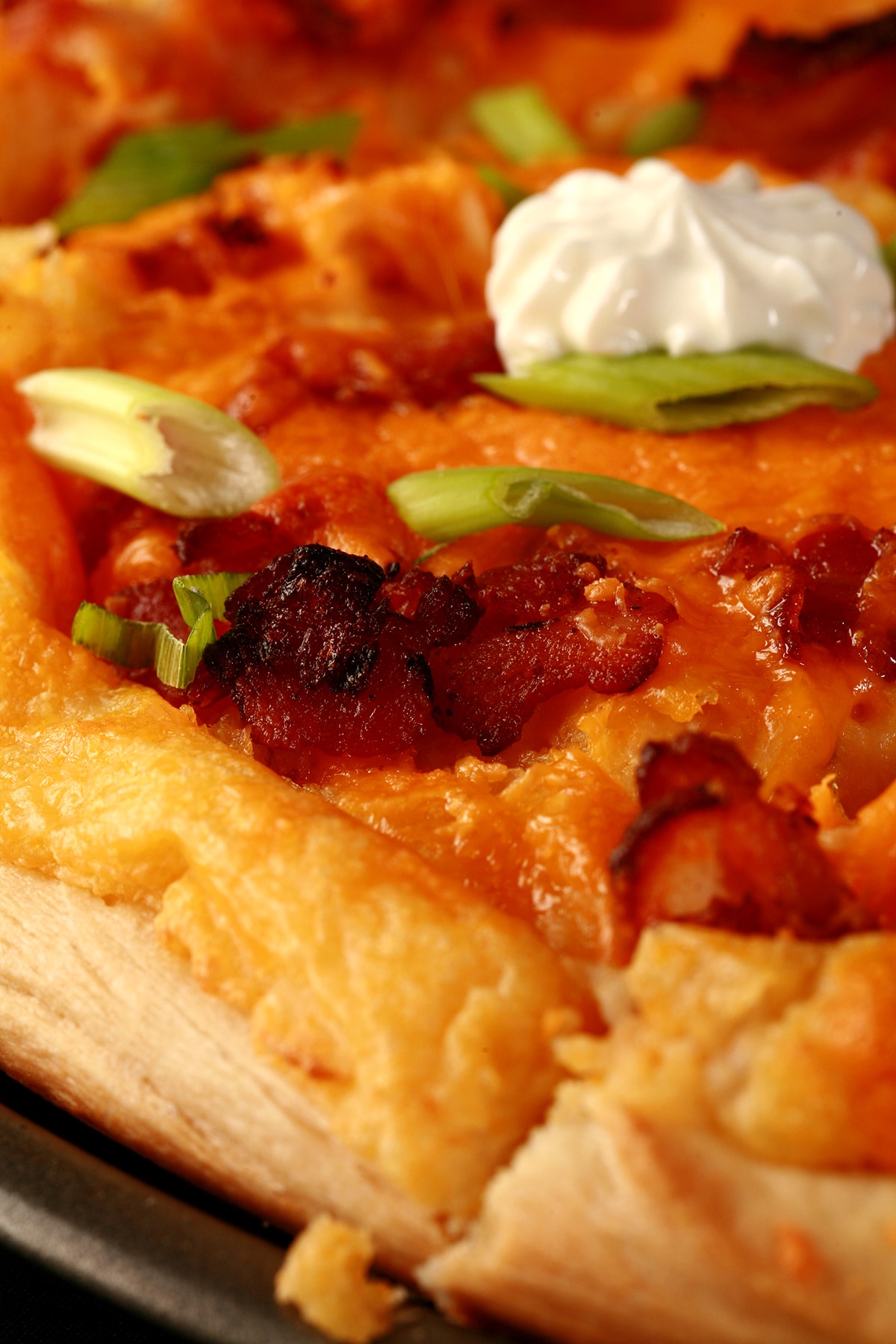 A whole Perogie Pizza - bacon, green onions, cheddar cheese, cheesy potatoes, and sour cream!