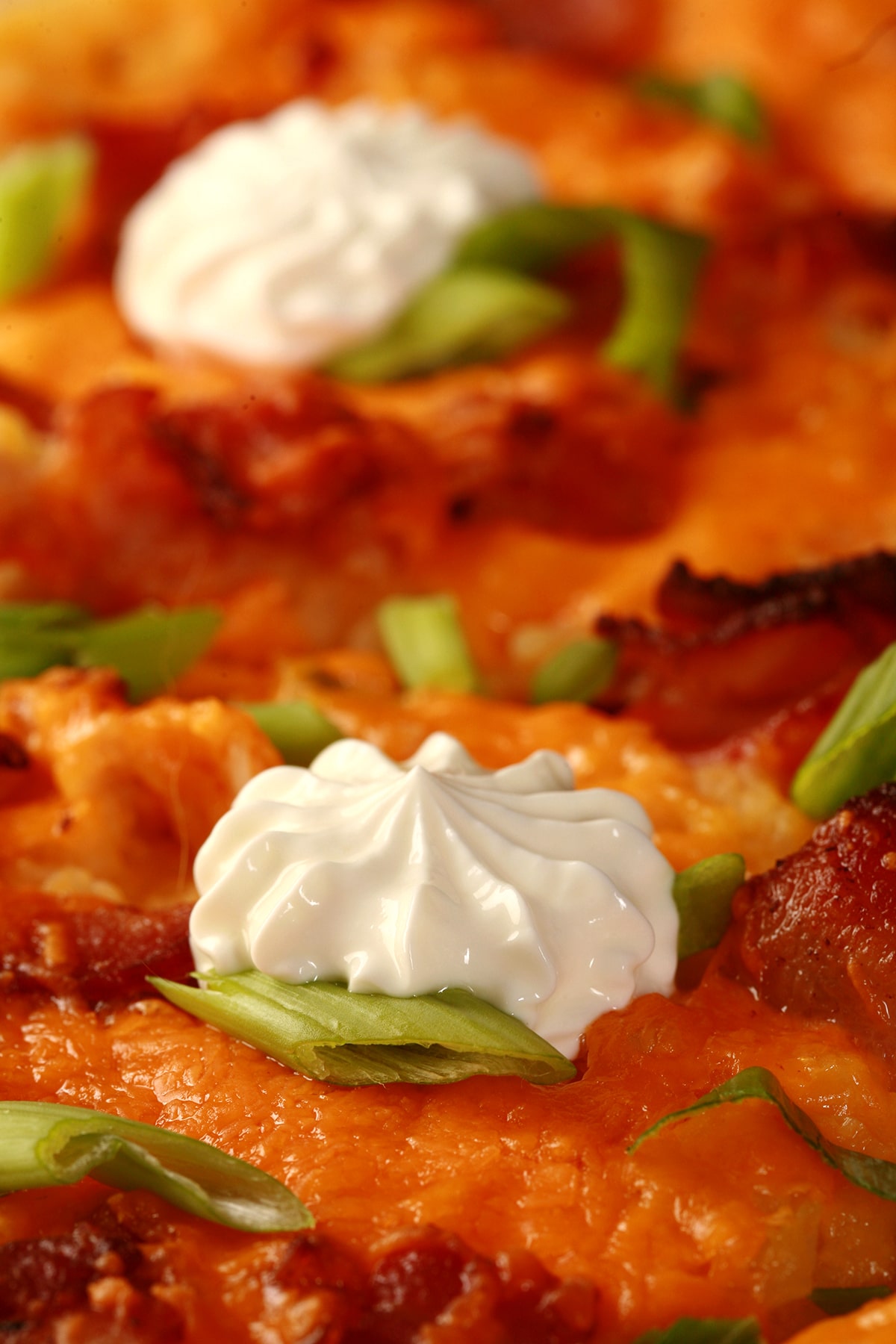 A whole Perogie Pizza - bacon, green onions, cheddar cheese, cheesy potatoes, and sour cream!