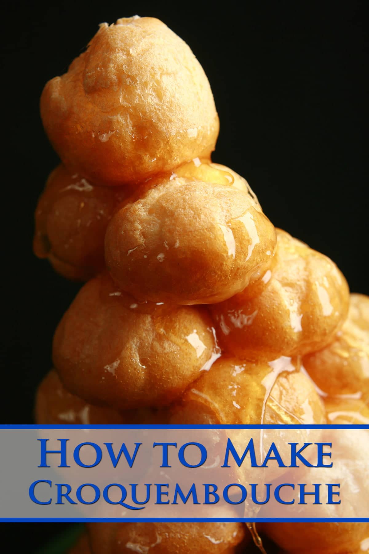 A small croquembouche - a tower made of small cream puffs held together with caramel - is pictured on a small green plate.