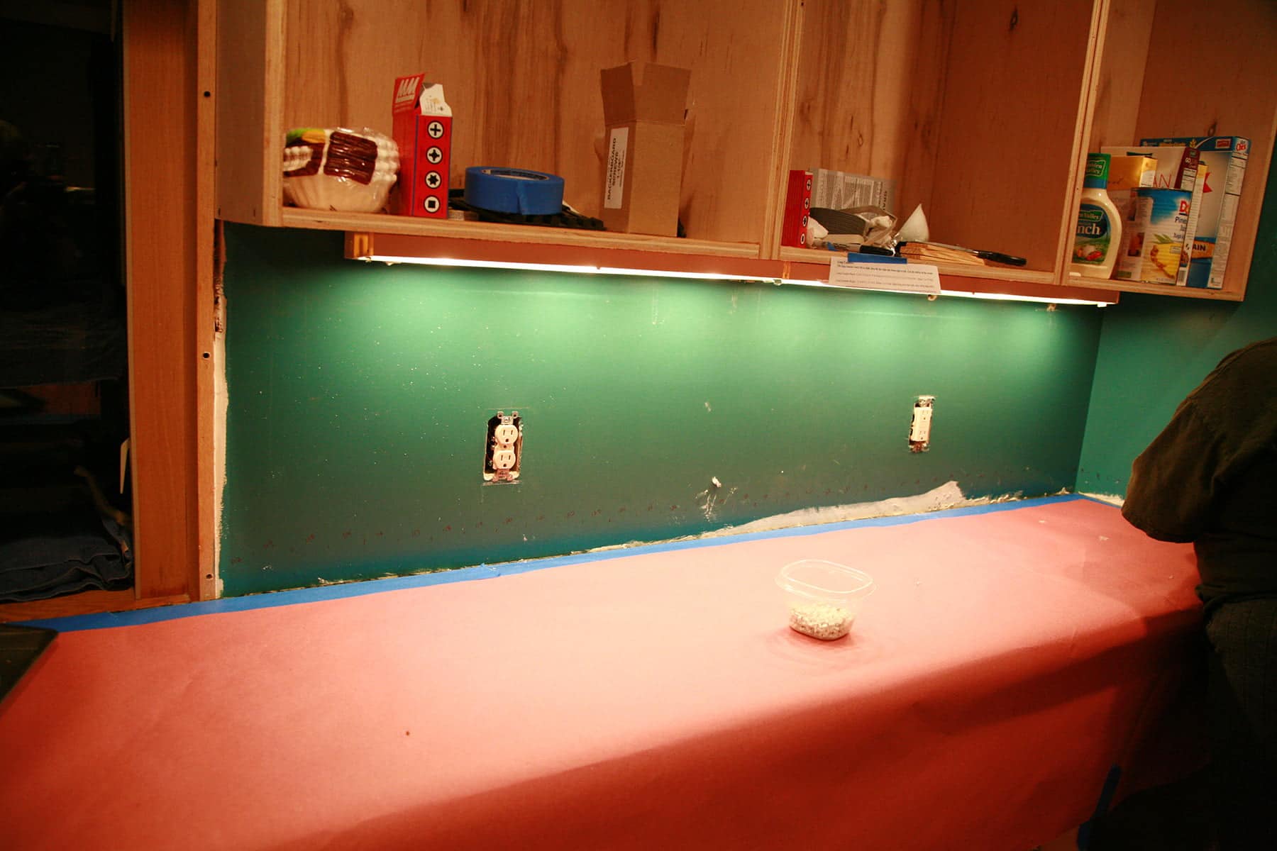 A counter top is covered in pink rosin paper, and the wall behind it has been sanded.