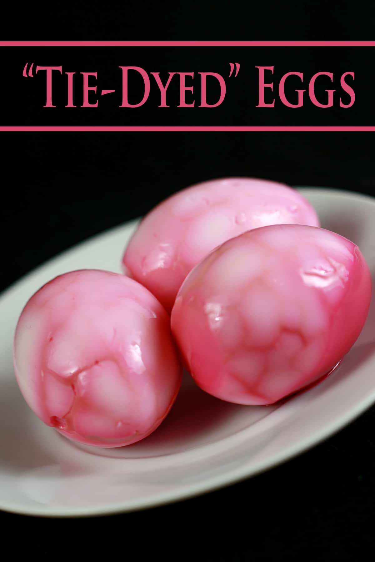 3 bright pink hard boiled eggs on a plate. They have a fractured "tie dye" design.