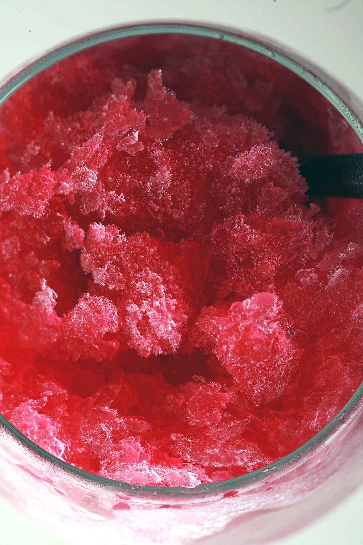 A close up view of a deep pink wine slush, made from our mix. It's in a frosted wine glass, and was made from our wine slush mix.