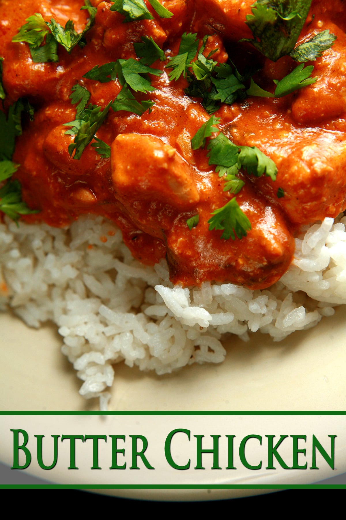 A close up view of Butter Chicken - Chicken in a  creamy tomato sauce, served over rice.