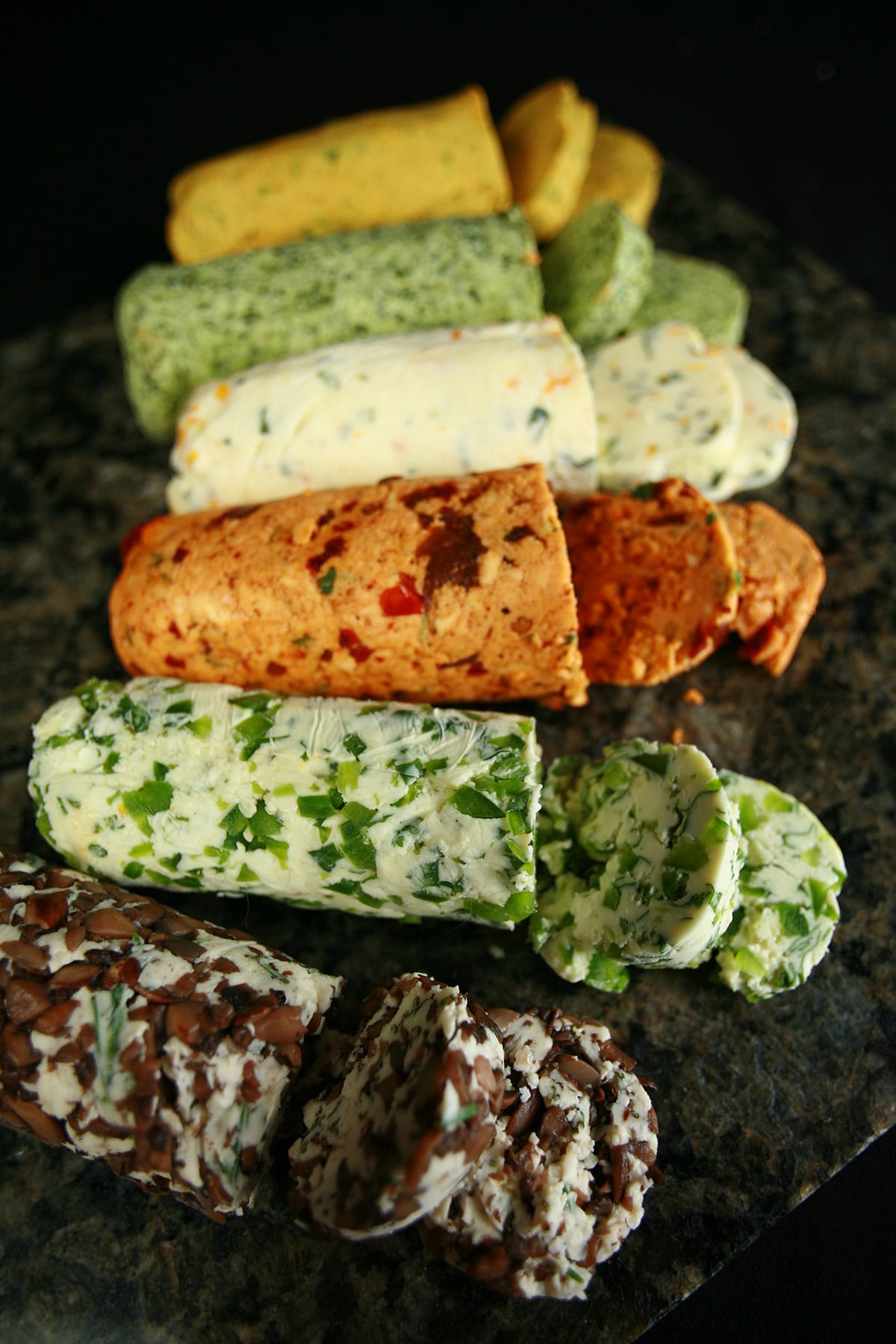 A row of compound butter logs in various colours and flavours.