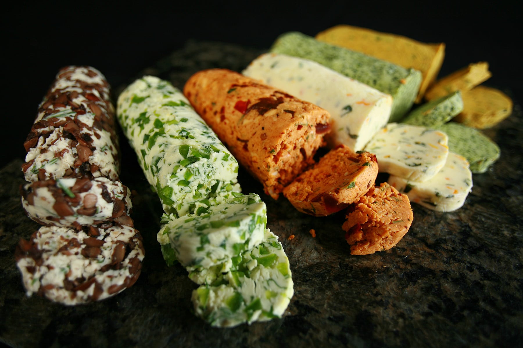 A row of compound butter logs in various colours and flavours.