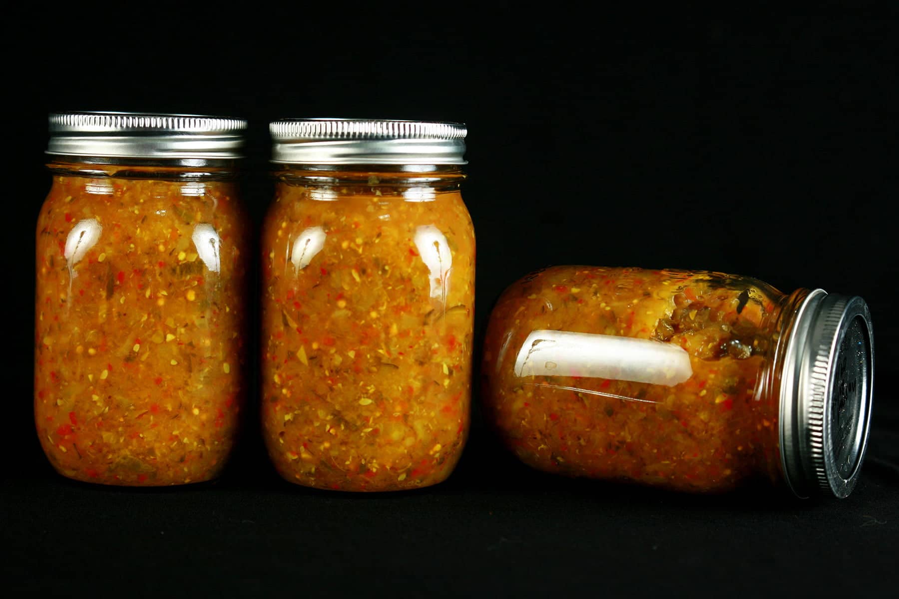 3 jars of Hoppy Dill Pickle Relish. It's a golden orange relish with flecks of dark green and red throughout.