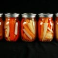 5 jars of mixed root vegetable pickles. Spears of carrot, parsnip, and turnip are visible.