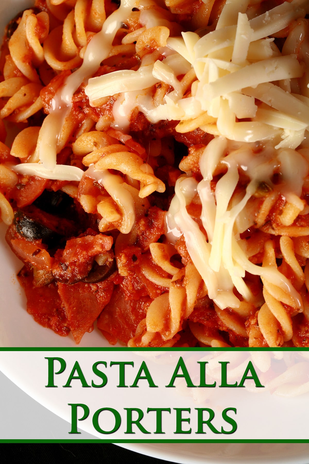 A bowl of pasta in red sauce, with bits of pepperoni and sliced black olives visible. There is shredded mozzarella on top - Pasta Alla Porters.