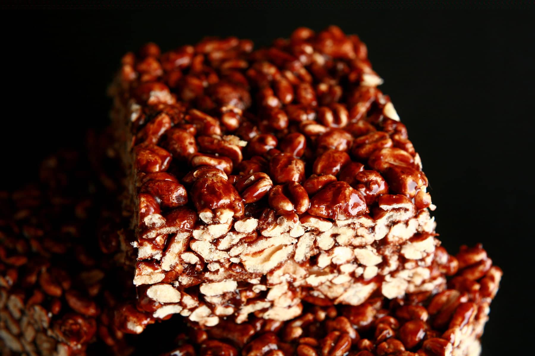 A small glass plate stacked with large pieces of puffed wheat bars.