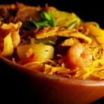 A large bowl of Singapore Mai Fan - curried vermacelli noodles with onion, celery, chicken, and shrimp visible throughout.