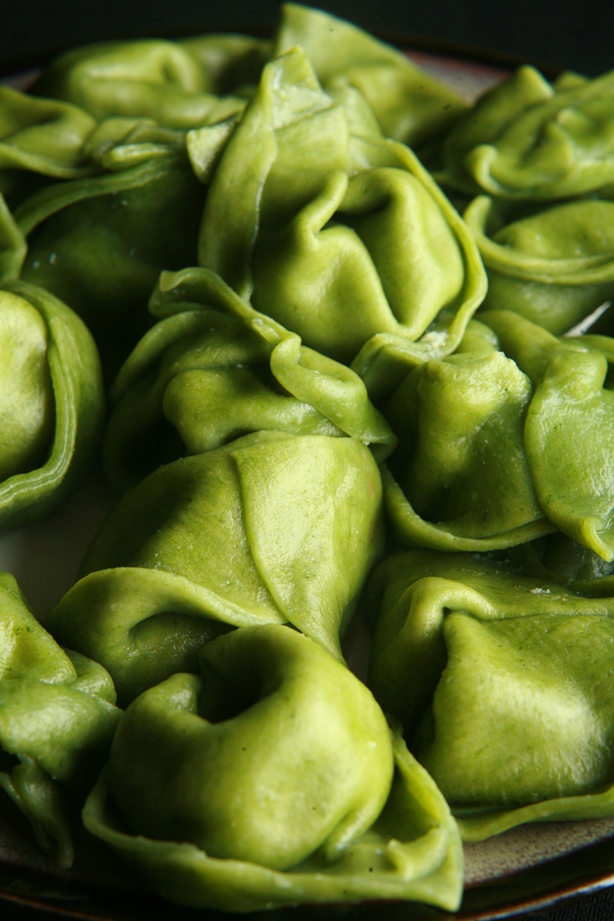 A plate of bright green spinach tortellini.