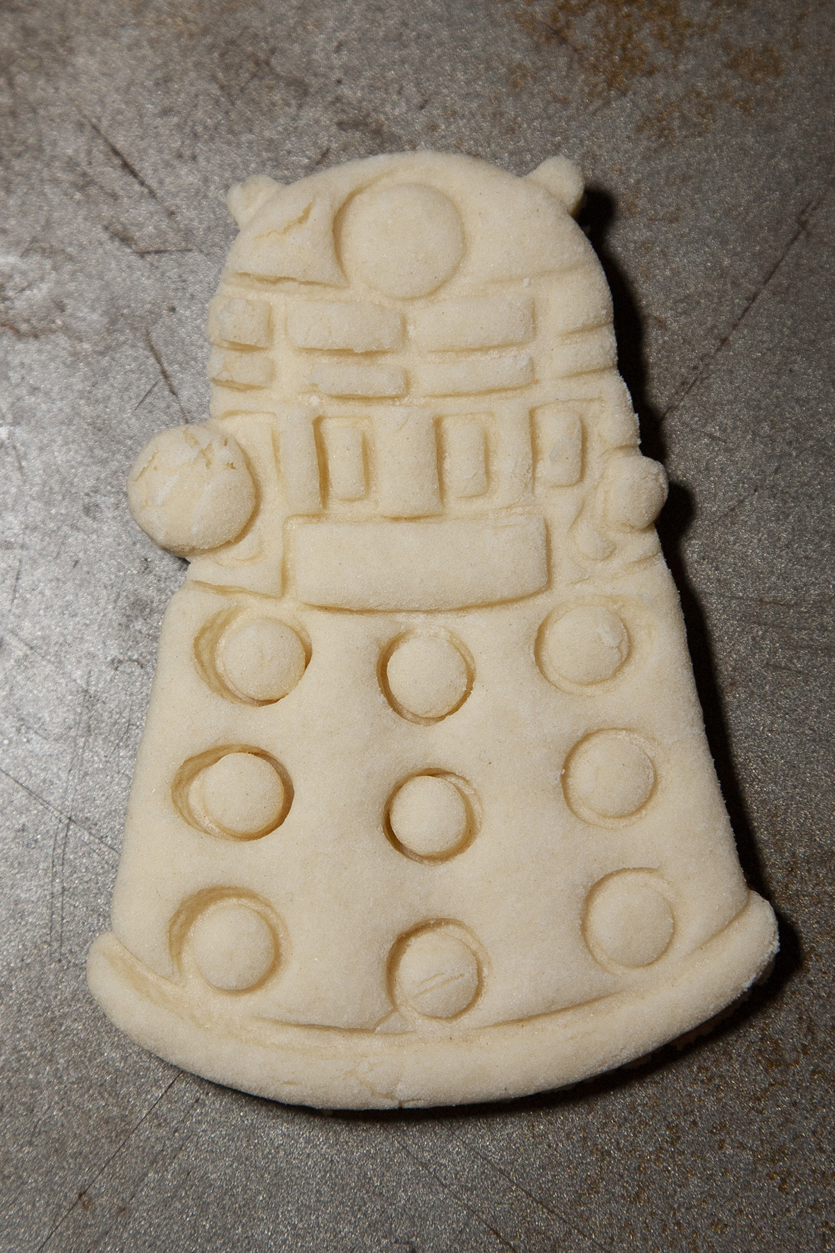 A undecorated Dalek shaped sugar cookie.