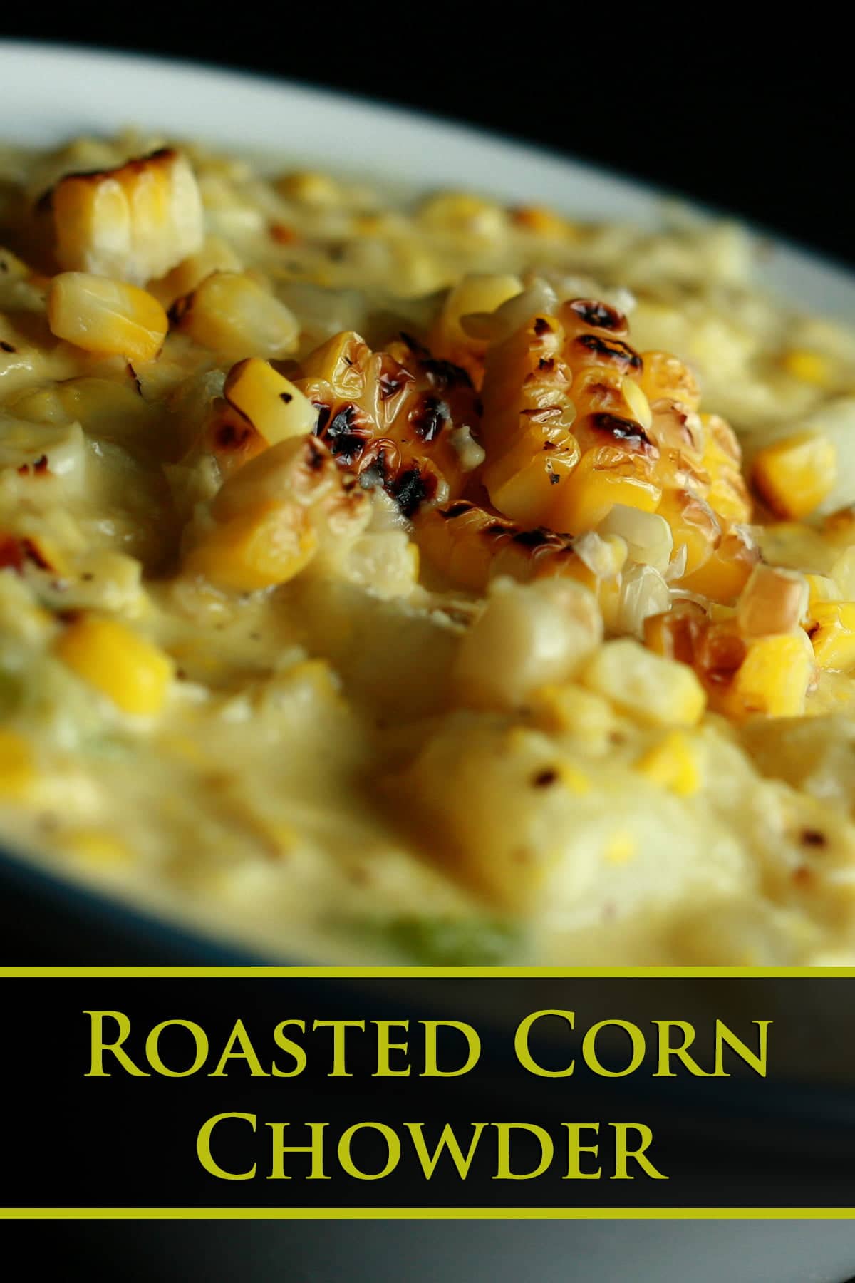 A white and cornflower blue bowl full of roasted corn chowder. Pieces of roasted corn garnish the surface of the soup.