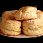 A small plate, stacked with golde, freshly baked biscuits.
