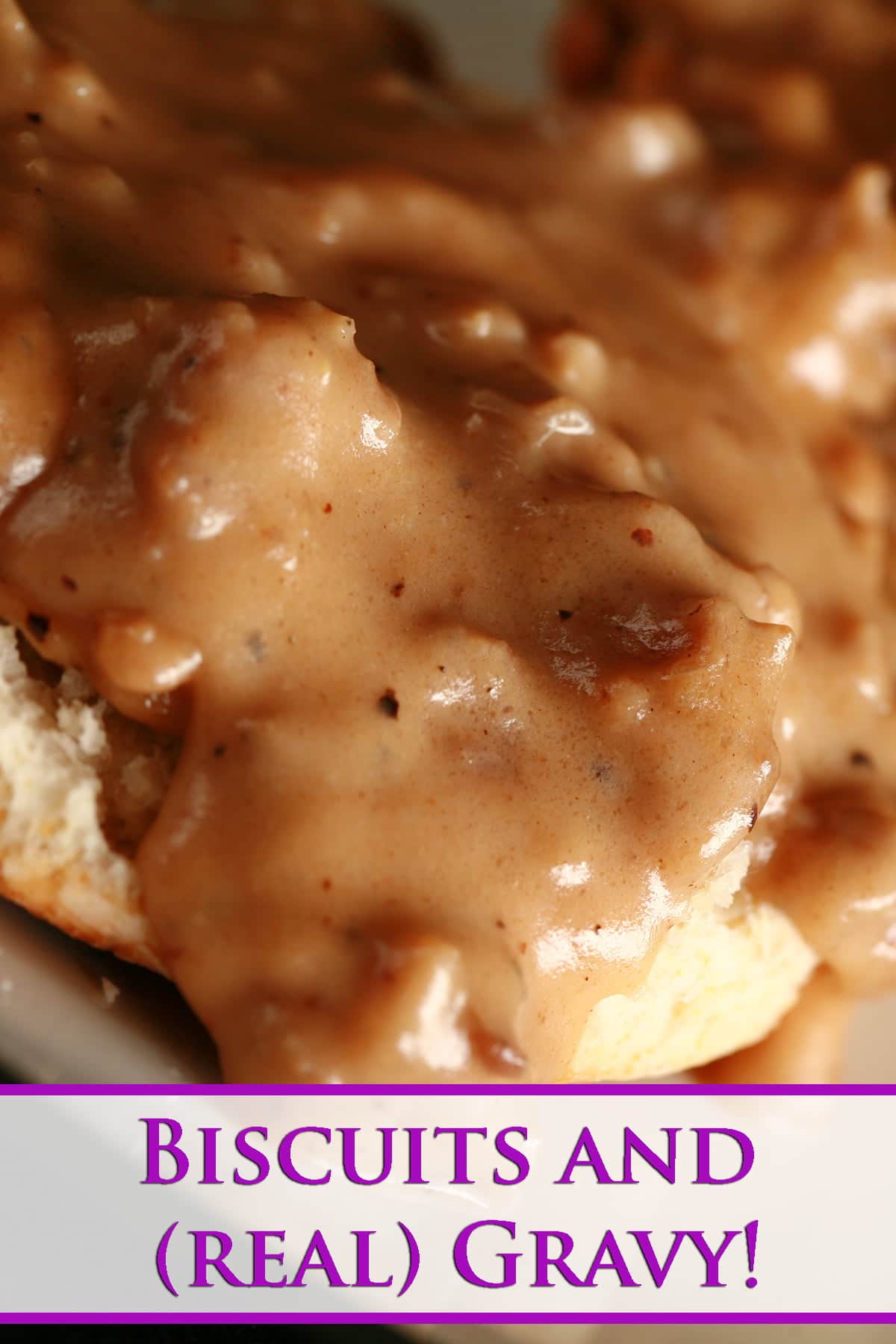 A close up view of a split biscuit covered with sausage gravy.