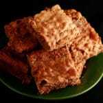 Several chewy chai blondies stacked on a small green plate.