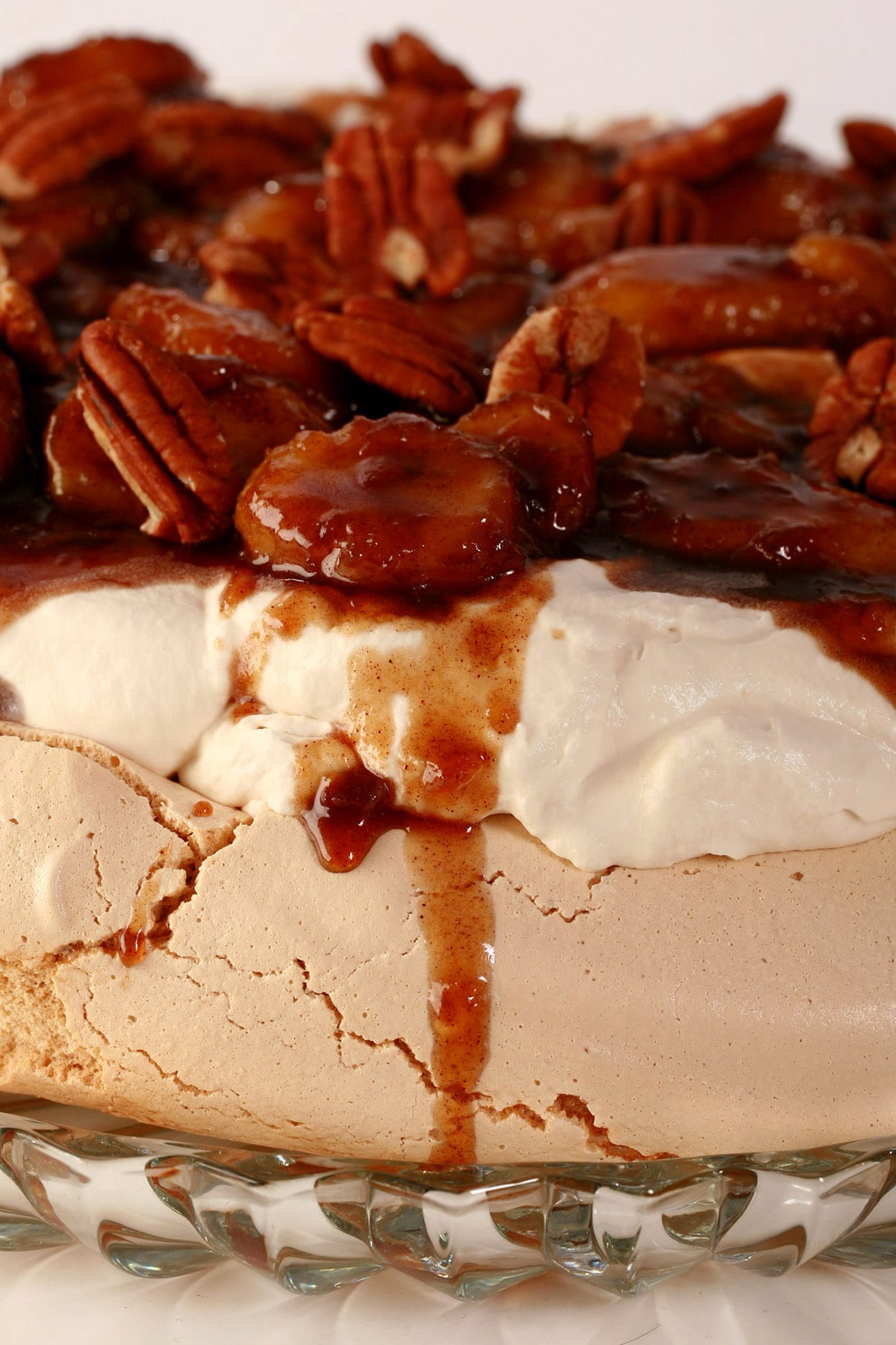 A very close up view of a brown sugar pavlova, topped with bananas foster.