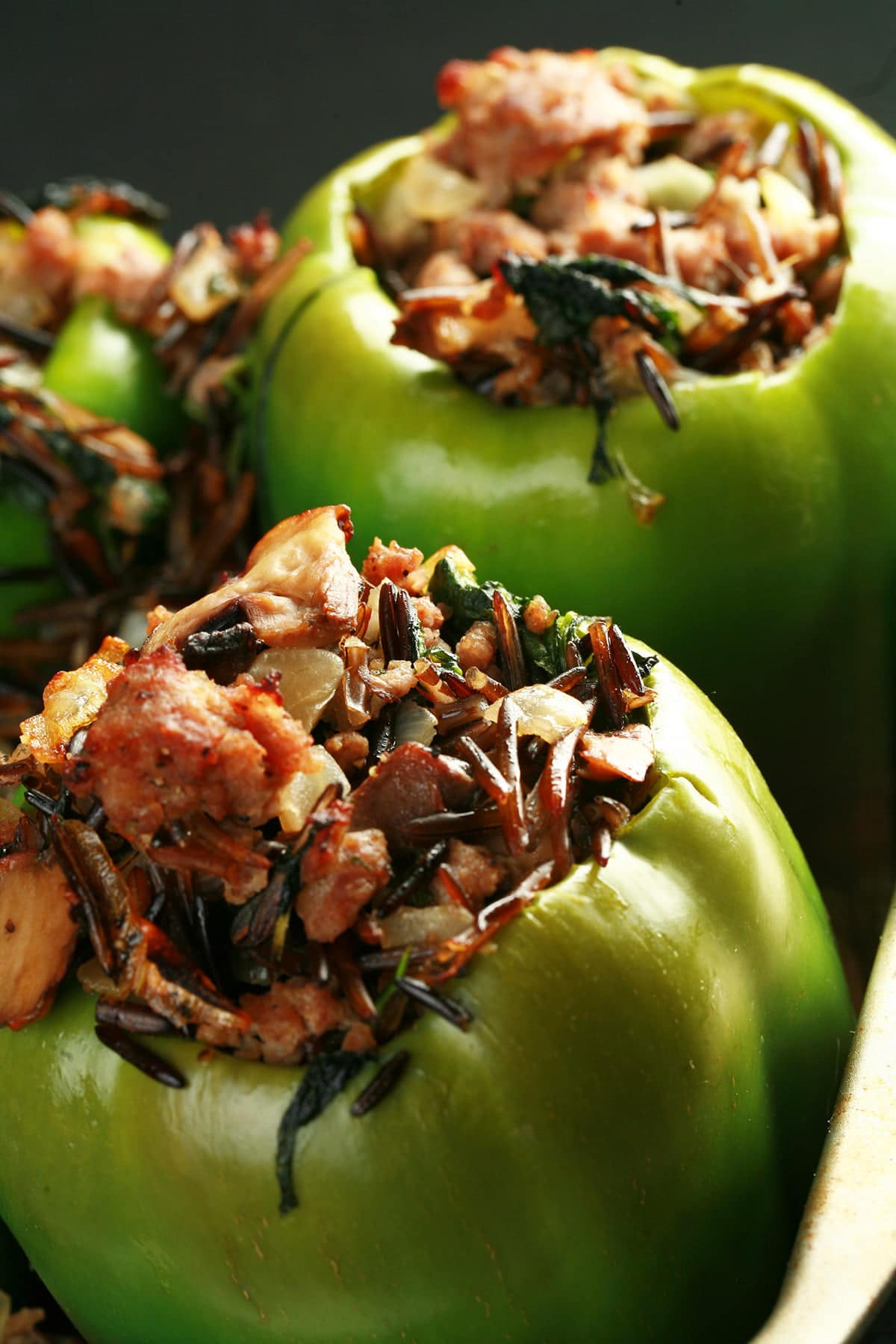 Close up view of a pan of wild rice and sausage stuffed peppers.