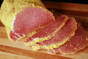A cured loin of pork that has been rolled in cornmeal and sliced - proper peameal bacon!