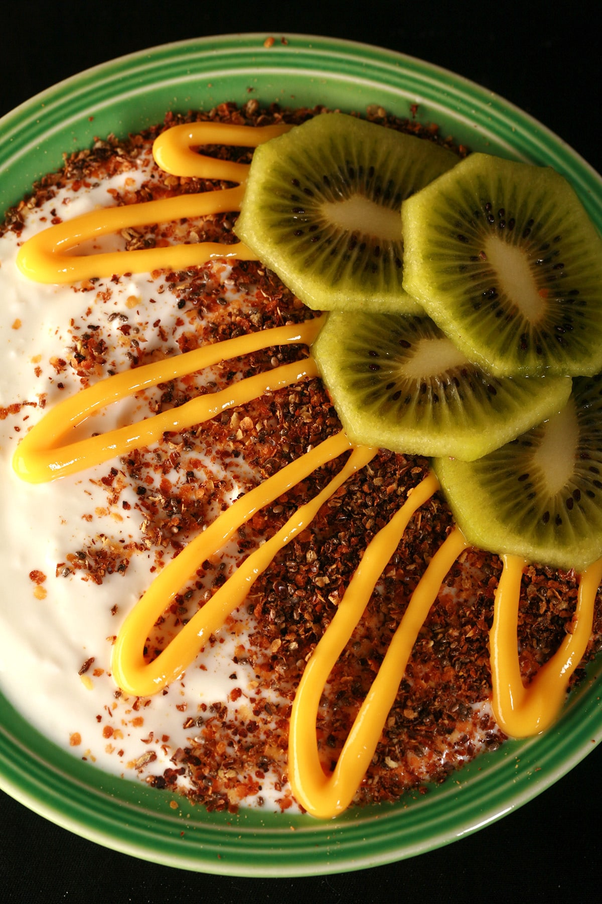 A bowl of vanilla yogurt, topped with our yogurt and ice cream topping, sliced kiwi, and a drizzle of mango curd.