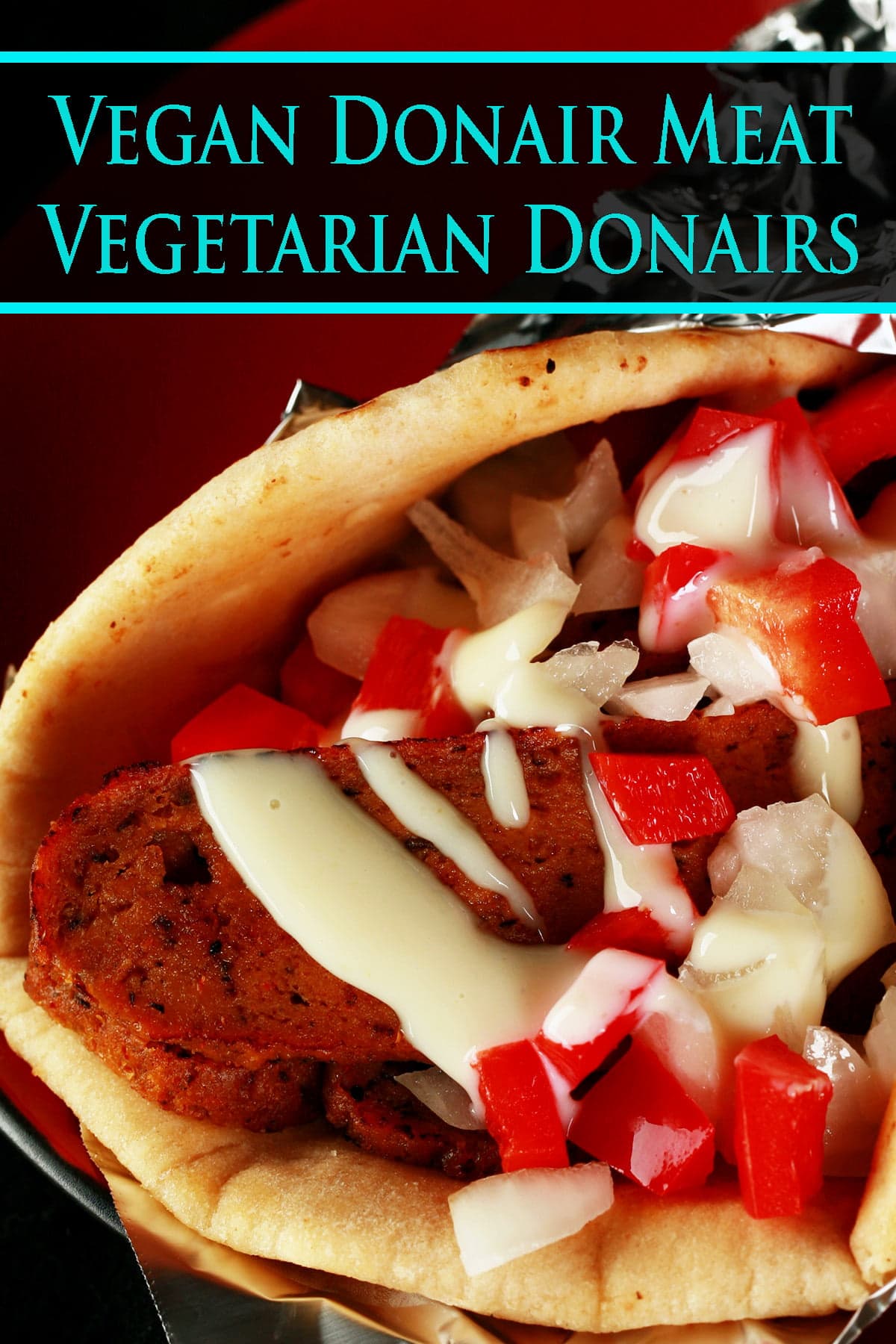 Close up view of a vegetarian donair - a pita bread folded around a pile of vegan donair "meat" slices, chopped red peppers, and donair sauce drizzled on top.
