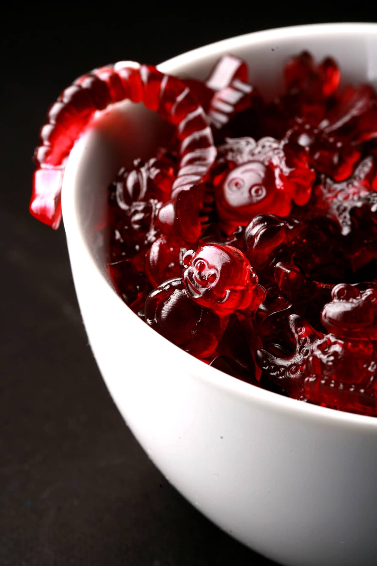 A white bowl full of tart cherry juice gummies, in various animal shapes.