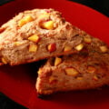 Two wedges of Rosemary Peach Balsamic Scones on a red plate. The scones are studded with visible chunks of peach.