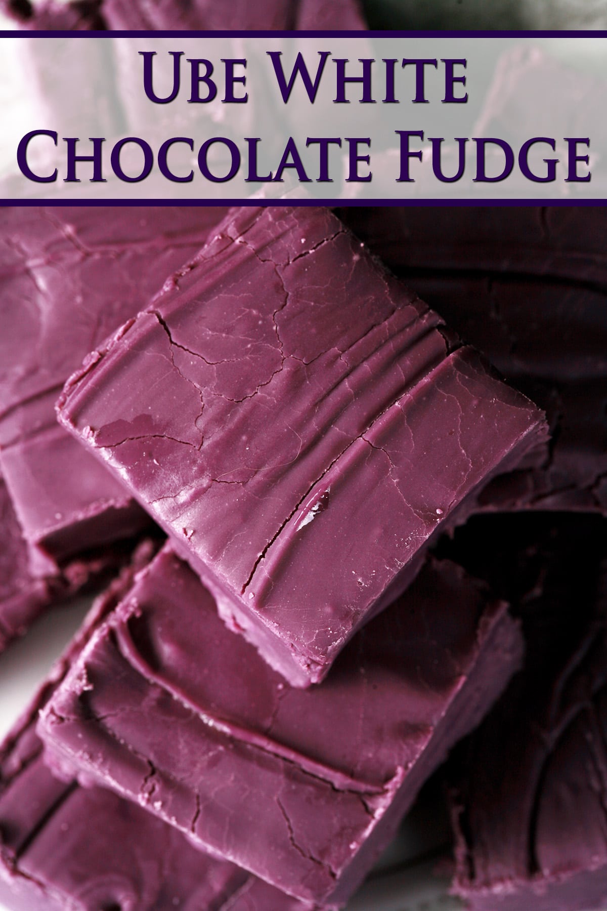 A small white plate stacked with squares of deep purple fudge. Purple text overlay says Ube white chocolate fudge.