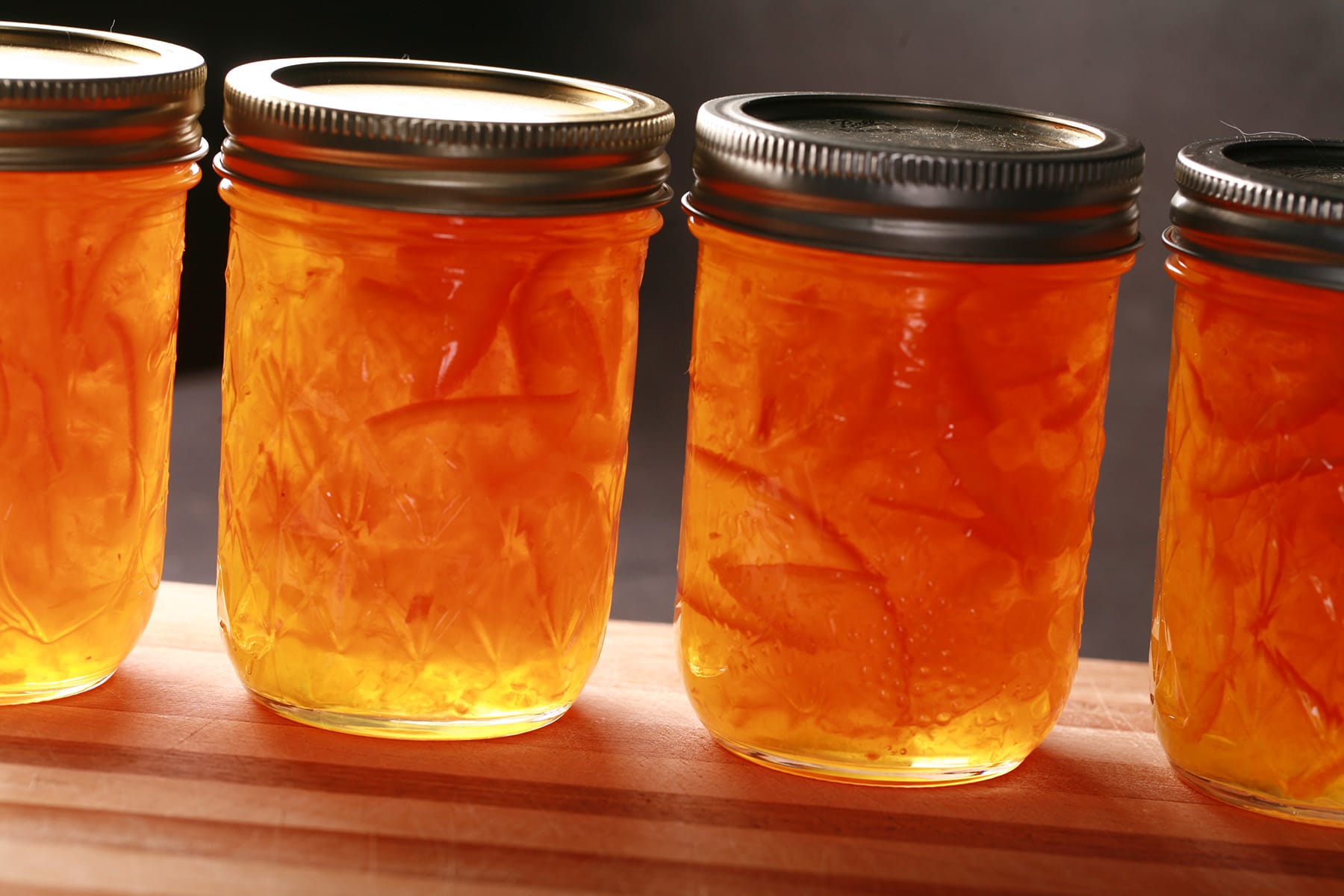 A row of small jars of clementine marmalade.