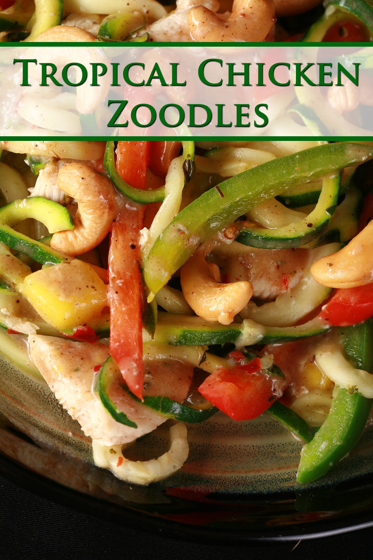 A plate of tropical chicken zoodle stir fry. Spiralized zucchini, pineapples, red pepper, cashews, and more.