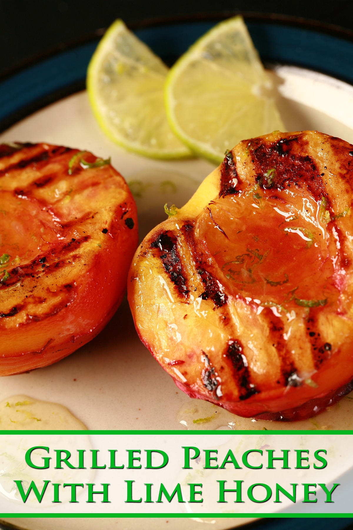 Two grilled peach halves on a plate, drizzled with lime honey.