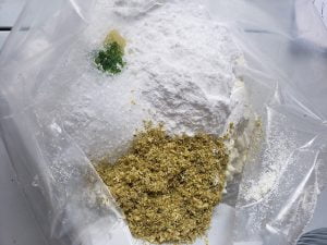 Close up view of a plastic baggie with powders in it, to make Hop Spa products