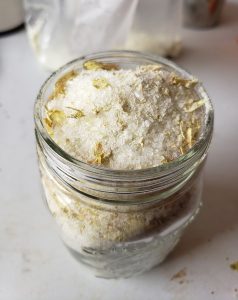 Close up view of a glass jar with powders in it, to make Hop Spa products